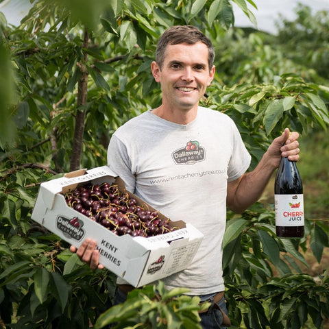 farmer of dallaway kentish english cherry juice holding the bottle and cherries
