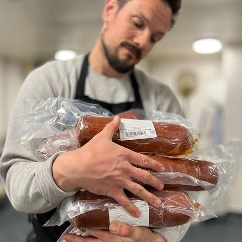 Person holding packages cobble lane cured nduja in a kitchen setting