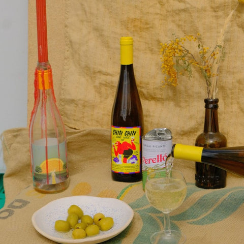 chin chin vinho verde noble rot being poured with olives next to it