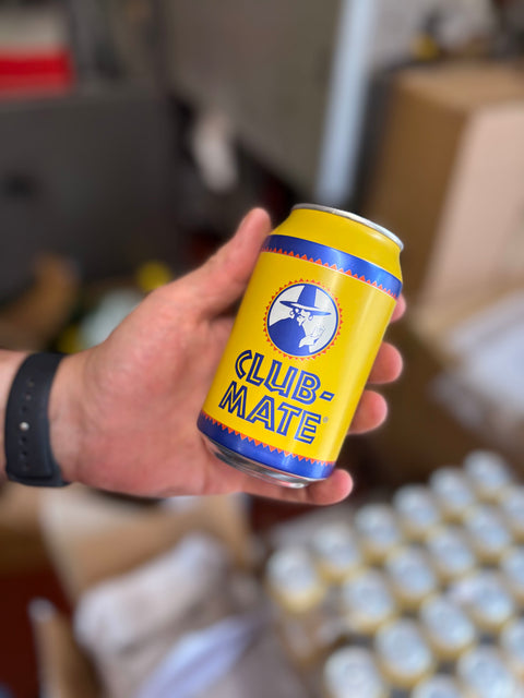 Hand holding a can of club mate