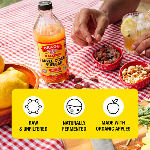 bottle of apple cider vinegar on picnic table with bowls of nuts and lemons and health facts