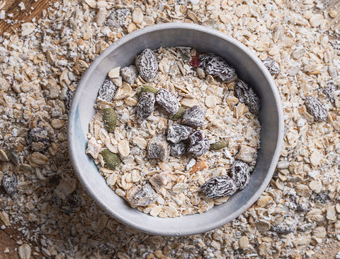 Bowl of granola with dried fruits on a wooden surface
