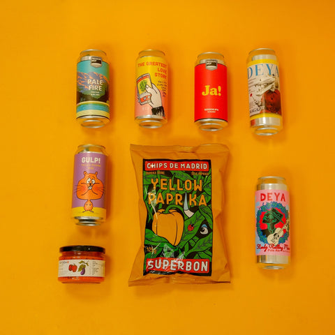 Assorted beer cans and a packet of yellow paprika on an orange background