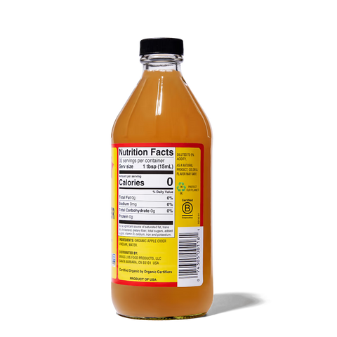 Bottle of apple cider vinegar with a nutrition facts label on a white background