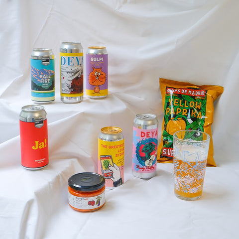 Assorted drinks and snacks including cans, a glass, and a jar on a white background