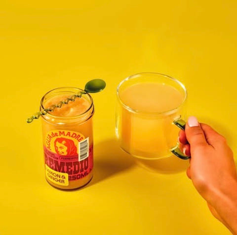 hot drink next to open jar of agua de madre lemon ginger