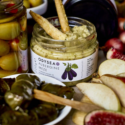 jar of meze with bread in it surrounded by various foods