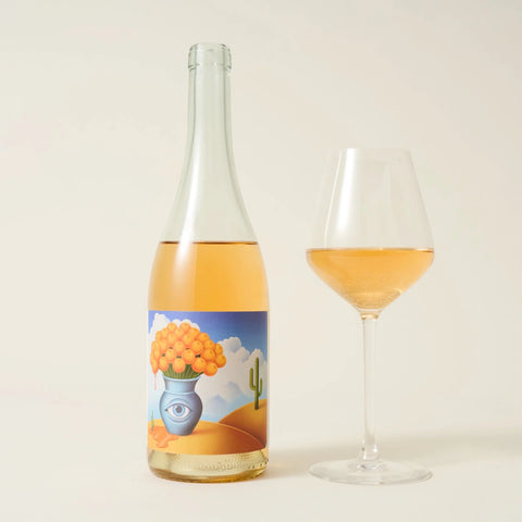 Bottle of other world orange wine next to glass of wine