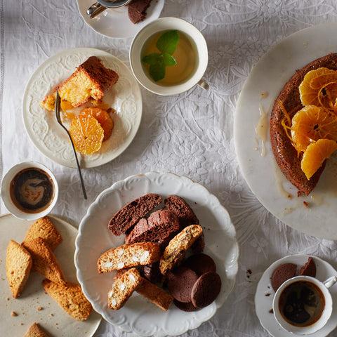 Assorted pastries and tea cups on a textured white surface