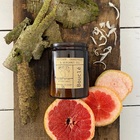 Boucle candle surrounded by grapefruit slices and bergamot