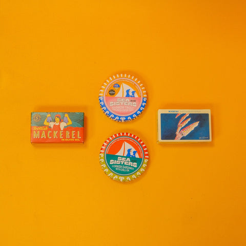 Four tins of british fish on an orange background