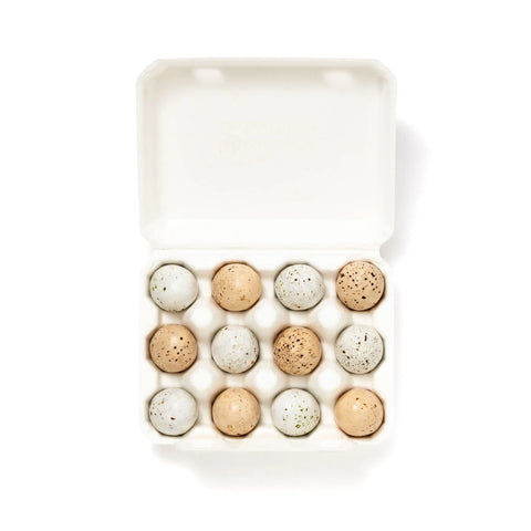  egg tray with speckled eggs on a white background