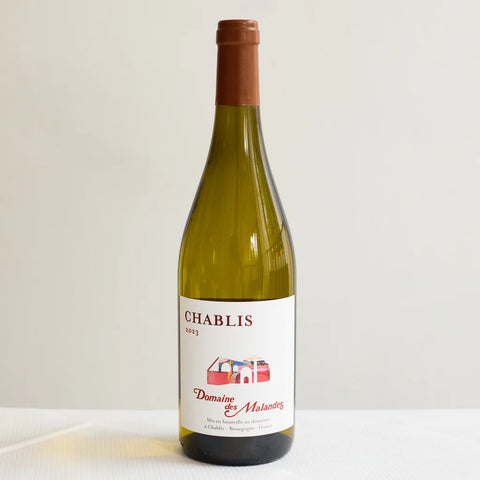 Bottle of Chablis wine with a white label on a light background