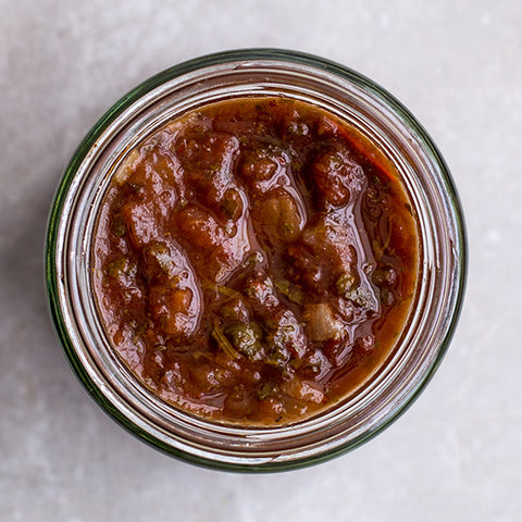 Jar of salsa on a light gray background