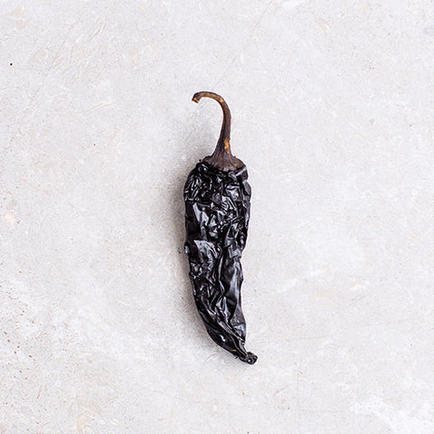 Dried black pepper on a white surface