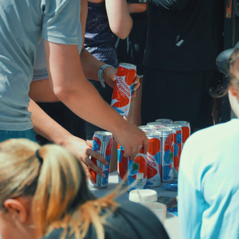 people grabbing cans of fountain of youth coconut water