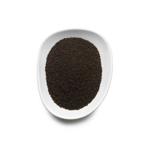 White dish with black seeds on a white background