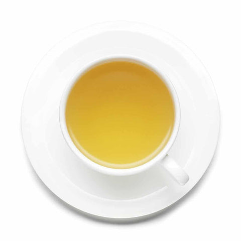 White cup and saucer with tea on a white background