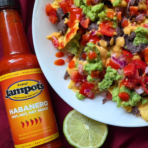 Habanero hot sauce next to bowl of chips