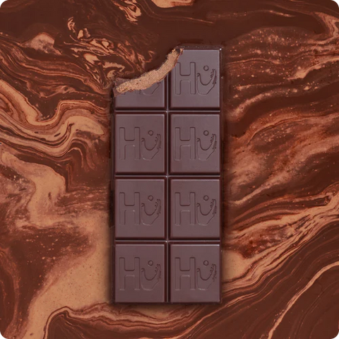 chocolate bar with bite taken out of it on a brown marble background