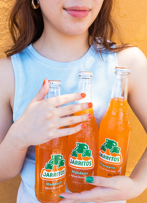 person holding three bottles of jarritos