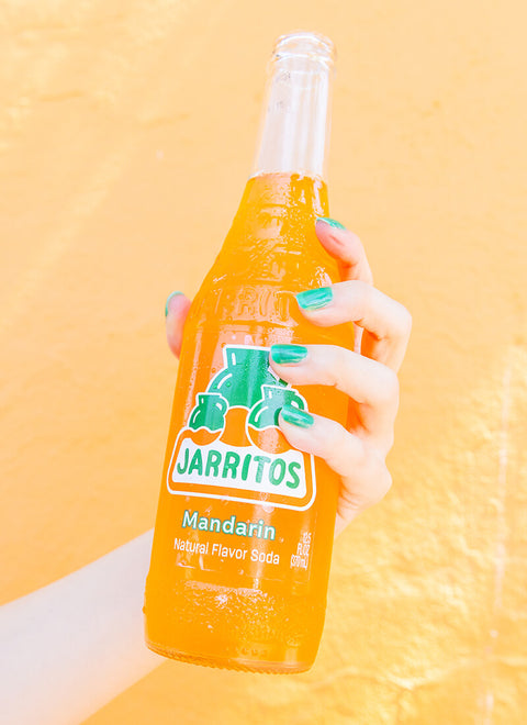 hand holding bottle of mandarin jarritos
