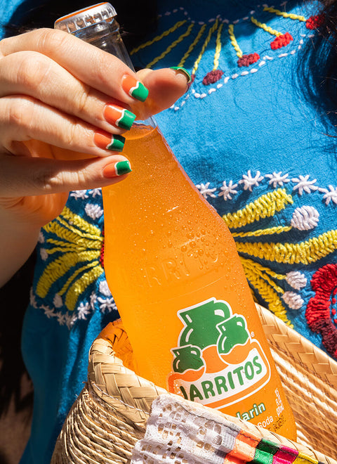 hand pulling bottle of jarritos out of bag