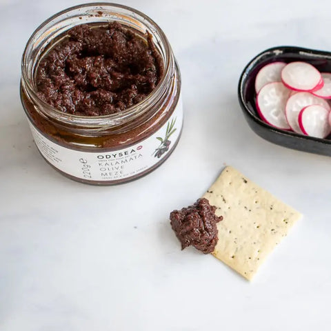 jar of meze on white surface next to a cracker