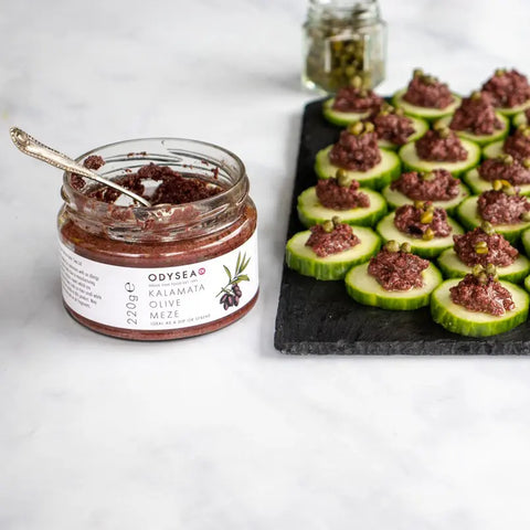 jar of meze next to cucumbers with meze on a board
