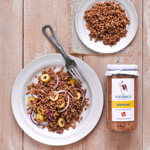 jar of lentils on wooden surface next to plates of lentils