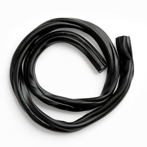 close up of strip of black liquorice on white background