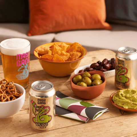 table with snacks and mash gang glug alc free beer cans
