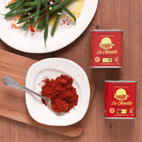 containers of la chinata and plates on a wooden surface