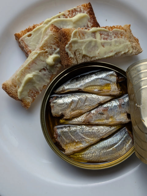 Open tin of cornish sardines with slices of buttered toast