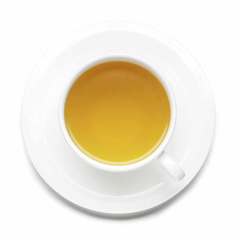 White cup and saucer with tea on a white background