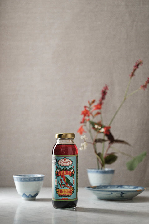 bottle of vinegar on table in front of plate and bowl