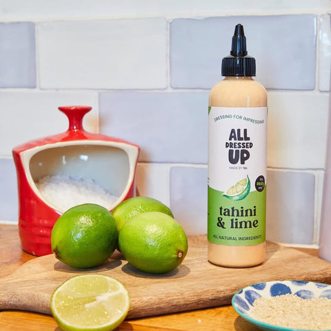 all dressed up tahini and lime dressing next to limes