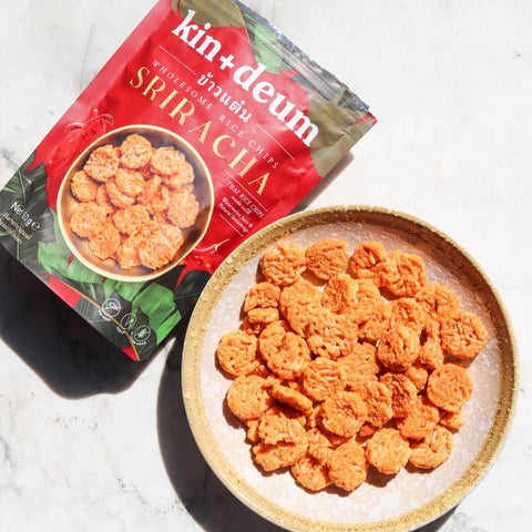 Kin+Deum Sriracha snack chips on a plate with packaging in the background.