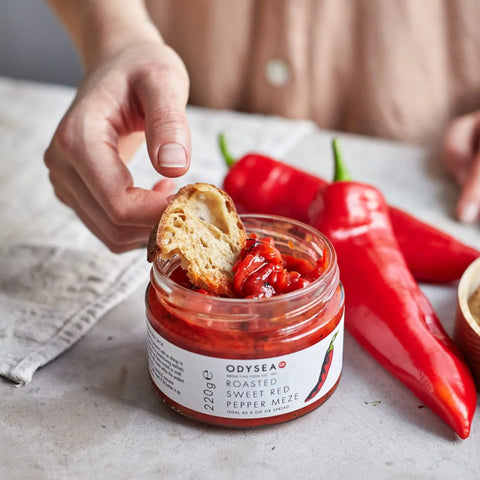jar of meze with a piece of bread dipped in it