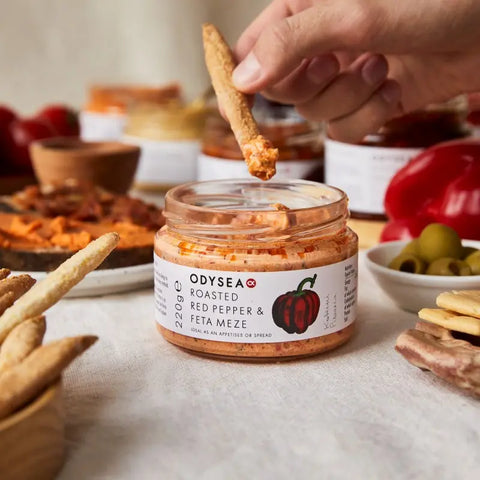 jar of meze with hand holding bread dipping it into the jar