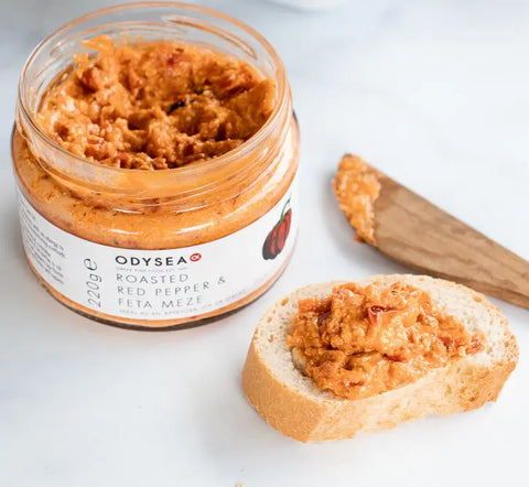 jar of Meze open on a white surface next to bread with meze on it