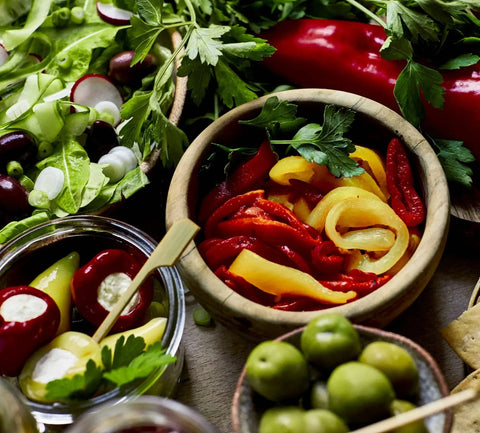 peppers in a bowl surrounded by mixed greens