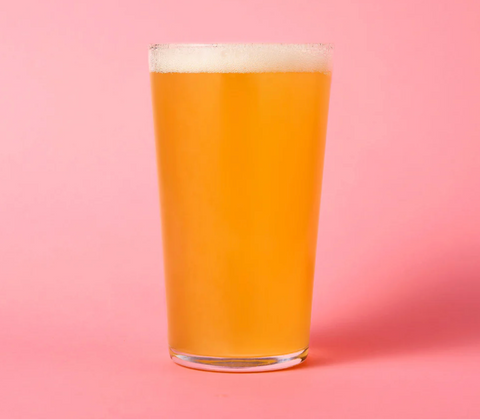 glass of beer on pink background