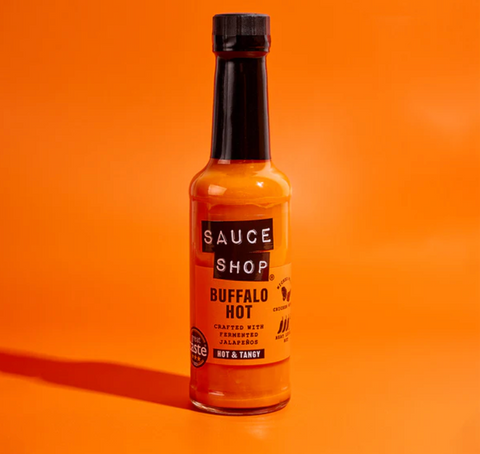 bottle of Sauce Shop Buffalo Hot on orange background