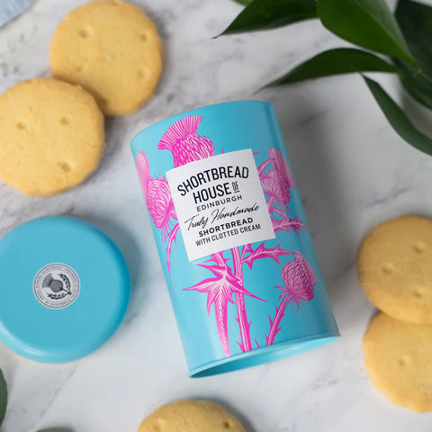 Clotted cream shortbread tin on it's back with biscuits around