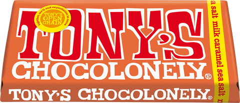 A close-up of a Tony's Chocolonely chocolate bar wrapper in orange-red with large red and white lettering and a yellow vertical side band.