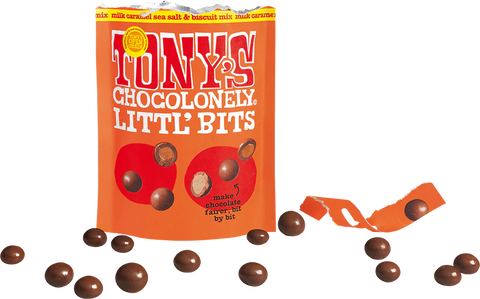 A bag of Tony's Chocolonely Little Bits chocolate candies on a white background, with several brown chocolate pieces scattered around the bag and a torn piece of orange packaging on the right.