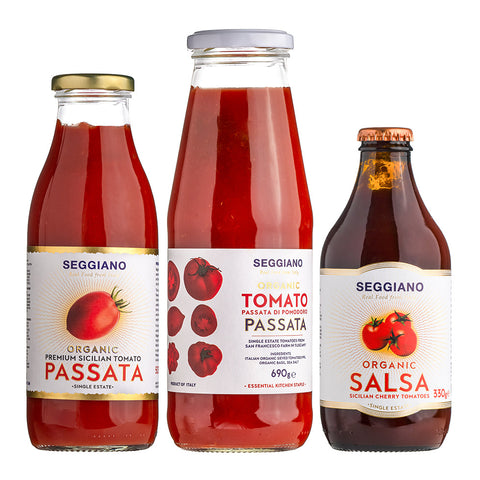 Three glass bottles of Seggiano Passata and Salsa tomato sauce on a white background, including a large bottle in the center and two smaller bottles on either side.
