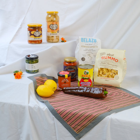 Assorted food products including jars, a bag, and lemons on a textured surface with a white background.