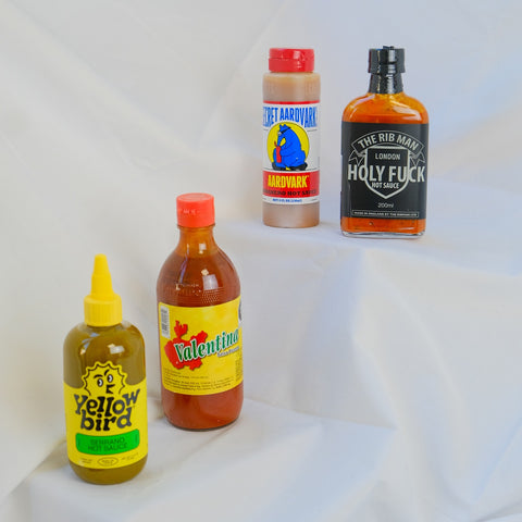 Five hot sauce bottles on a white background